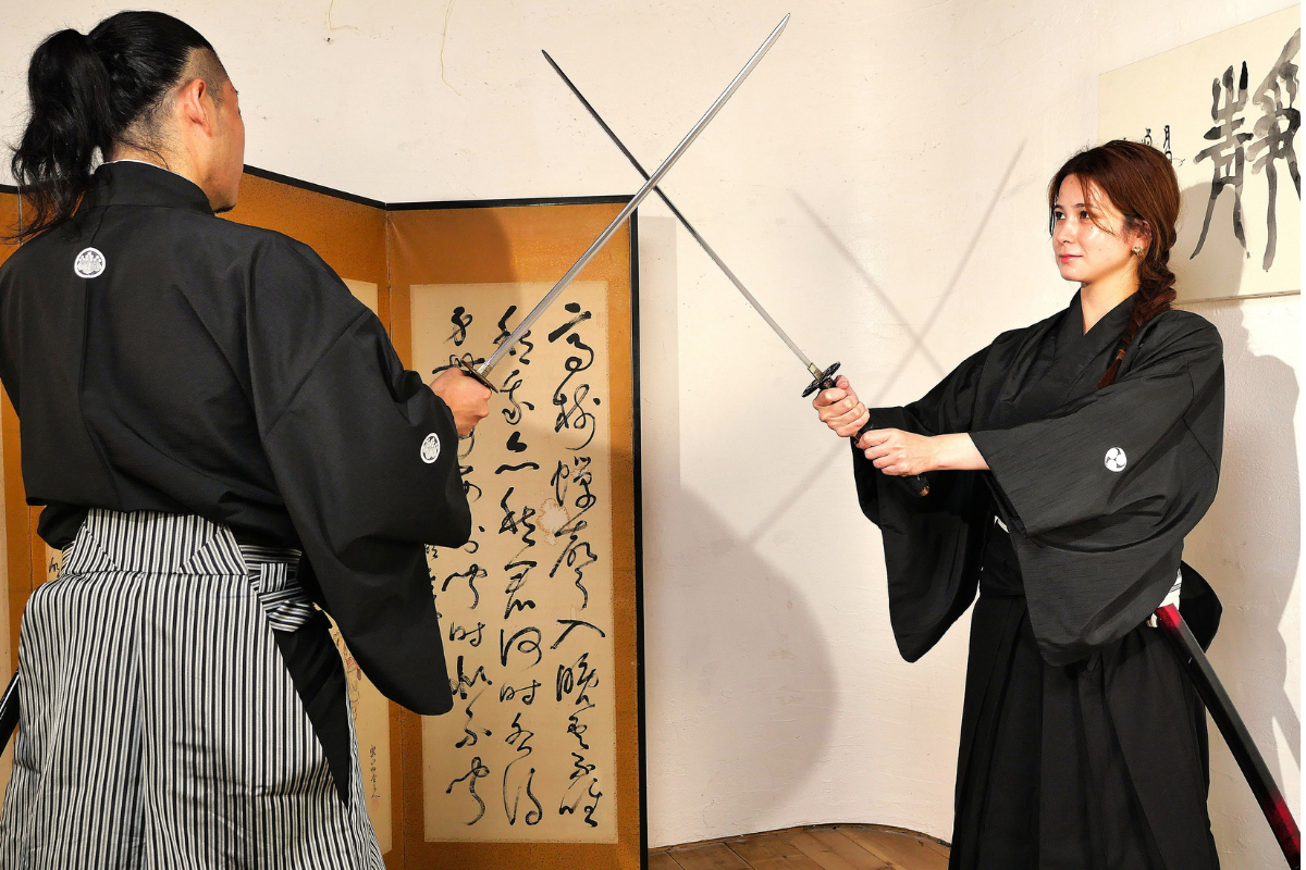 Participants practicing Samurai sword techniques under the guidance of a Samurai master