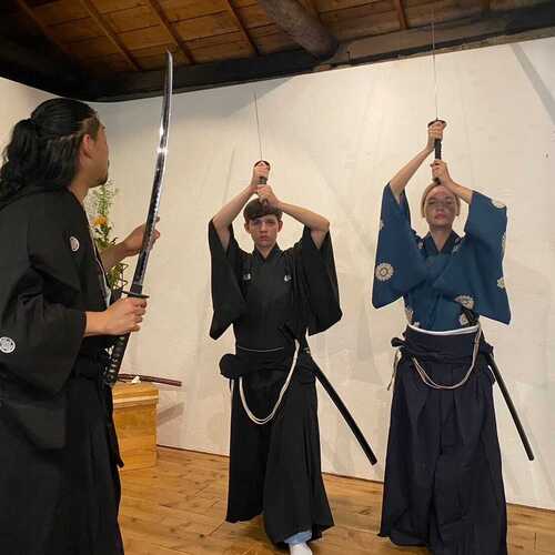 Participants learning Samurai sword movements during a Bushido workshop